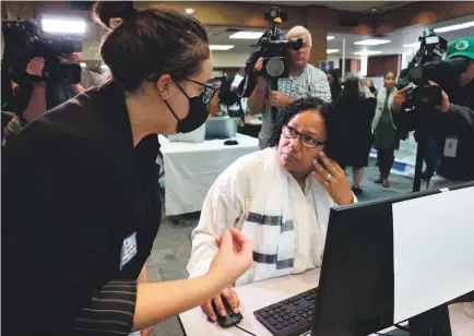  ?? MARC VASCONCELL­OS/USA TODAY NETWORK ?? Ella Azoulay of the Student Borrower Protection Center helps Giselle Morton of East Bridgewate­r, Massachuse­tts, with her student debt loan at Massasoit Community College in October.