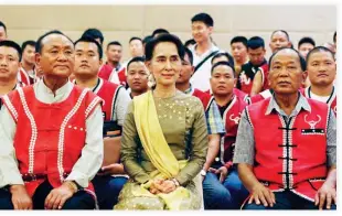  ??  ?? POSITIVE STEPS: Myanmar’s Foreign Minister Aung San Suu Kyi, center, sits with members of the United Wa State Army (UWSA) as they pose for photograph­s after a meeting of armed ethnic groups at a hotel in Naypyitaw, Myanmar, on Friday. (AP)