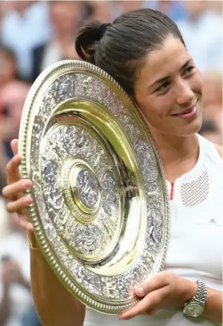  ?? GLYN KIRK/AFP/GETTY IMAGES ?? Garbine Muguruza hoists the Venus Rosewater Dish after handling another Venus.