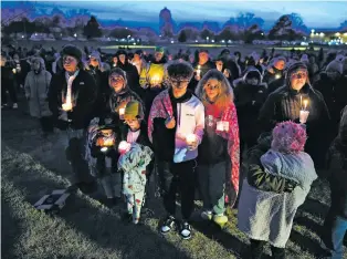  ?? CHARLIE NEIBERGALL/THE ASSOCIATED PRESS ?? Residents at a candleligh­t vigil Thursday at Perry High School in Perry, Iowa.