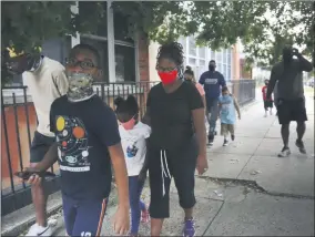  ?? JESSIE WARDARSKI—ASSOCIATED PRESS ?? St. Francis Xavier School students and their families walk together in Newark, on Thursday, Aug. 6, 2020, after discussing the Catholic school’s permanent closure announced the previous week by the Archdioces­e of Newark. Nationwide, more than 140 Catholic schools will not reopen in the fall.