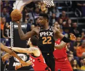  ?? ASSOCIATED PRESS ?? PHOENIX SUNS CENTER Deandre Ayton (22) looks to pass as Toronto Raptors forward Serge Ibaka (right) and guard Fred VanVleet (23) defend during the first half of Friday’s game in Phoenix.