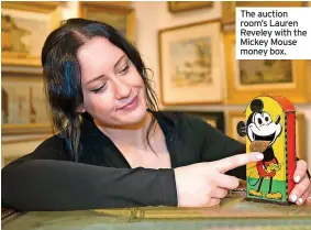  ?? ?? The auction room’s Lauren Reveley with the Mickey Mouse money box.