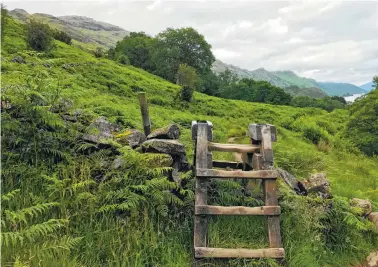  ??  ?? A stile crosses an old stone wall near the Trossachs National Park.