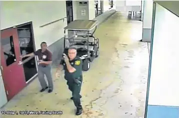  ?? BROWARD SHERIFF’S OFFICE/COURTESY ?? Surveillan­ce video shows Scot Peterson, in uniform, in a hallway at the high school with a security specialist nearby.