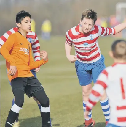  ??  ?? New Herrington St Aidan’s Under-12s (orange) in action against HFC United.