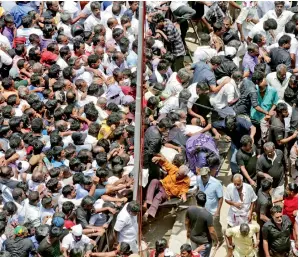  ?? AP ?? Supporters of Karunanidh­i fall on each other as they rush to pay last respects to their leader in Chennai on Wednesday. —