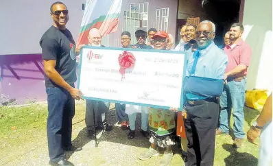  ?? PHOTO BY BRYAN MILLER ?? Gary Whittaker (left), managing director of Garmic Ventures Limited, which operates GV Service Stations, presents a cheque for more than $500,000 to the Reverend Sheldon Ashman (right), president of the Hanover Ministers Fraternal, which runs the Kitchen of Love in Lucea, Hanover, on Tuesday. Other volunteers at the Kitchen of Love share in the occasion.