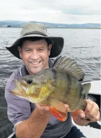  ?? PHOTO: SUPPLIED ?? Bagged . . . Otago Fish and Game chief executive Ian Hadland with a 1.5kg redfin perch at Lake Waihola.