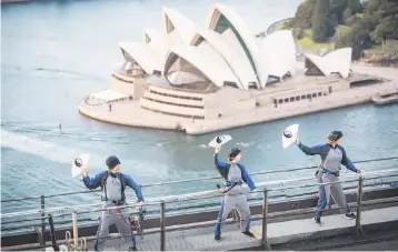  ??  ?? This handout photo taken and released by BridgeClim­b Sydney on May 2, shows participan­ts performing their moves during the world’s first tai chi class at dawn at the top of the Sydney Harbour Bridge. Australia’s central bank held interest rates at a...