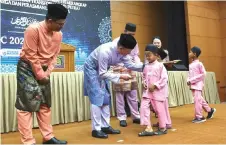  ?? Photo — Bernama ?? Fadillah presents ‘duit raya’ to an orphan during the gathering.