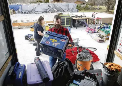  ?? BILL LACKEY / STAFF ?? Jon Stewart and his family load the last of their belongings in the back of a U-haul truck parked where his garage once stood Monday. Stewart’s house on Mitchell Road was destroyed by the Feb. 28 tornado that hit the area.