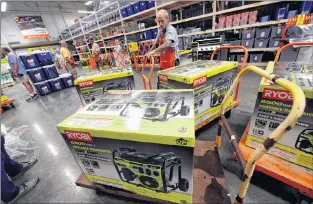  ?? AP PHOTO ?? Brian Franklin prepares more generators for sale as people buy supplies at The Home Depot on Monday in Wilmington, N.C.