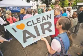  ??  ?? Theresa Underwood holds signage during Tuesday’s rally. The event was in support of the environmen­t and the EPA, health care for all, fair and humane immigratio­n policies and an independen­t investigat­ion of Russian influence in the 2016 U.S. elections.