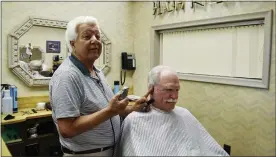  ?? GINA JOSEPH — THE MACOMB DAILY ?? Phillip “Phil” Minnella, 85, and founder of Phil’s Styling Shop in Clinton Township gives the honor of the final haircut of his career, Thursday, to his longtime customer, Tom Denewith. After 66years, he is retiring so he can spend more time with his friends and family.