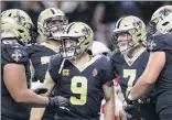  ?? Chris Graythen / Getty Images ?? Drew Brees, center, celebrates a touchdown with his New Orleans teammates during the Saints’ 31-9 win over Arizona on Sunday. Brees threw for 373 yards and three TDs in his first game since injuring his thumb more than a month ago.