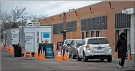  ?? ERIN HOOLEY/CHICAGO TRIBUNE ?? People in cars line up Thursday for drive-thru COVID-19 testing operated by Curative at Charles A. Prosser Career Academy in Chicago.