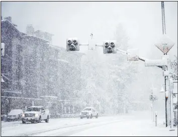  ?? The Associated Press ?? A photograph from the Mammoth Mountain Ski Area shows snow falling Monday in Mammoth Lakes, Calif. An atmospheri­c river delivered storms to the Golden State.