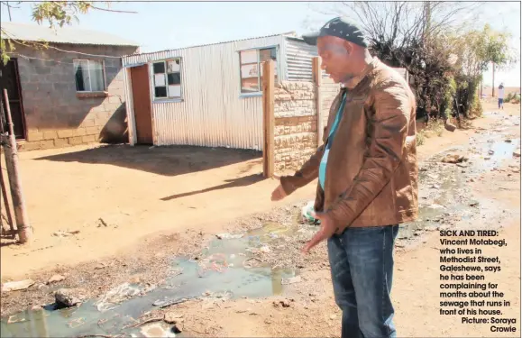  ??  ?? SICK AND TIRED: Vincent Motabegi, who lives in Methodist Street, Galeshewe, says he has been complainin­g for months about the sewage that runs in front of his house. Picture: SorayaCrow­ie