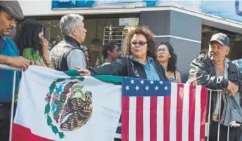  ?? Hans-maximo Musielik, The Associated Press ?? Lilia Lara, a Tijuana resident, displays the U.S. and Mexican flags at the plaza where Mexican President Andres Lopez Obrador later held a rally Saturday in Tijuana, Mexico.