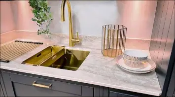  ?? Getty Images / Getty Images/iStockphot­o ?? Consider metallics as well when you’re searching for hardware. Here, gold features in the sink, faucet and cabinet handles.