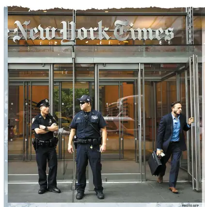  ?? PHOTO AFP ?? Deux policiers de la ville de New York montent la garde à l’entrée du quotidien The New York Times hier tout de suite après la fusillade dans un quotidien de l’État du Maryland.