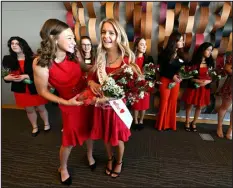  ?? PHOTOS BY JENNY SPARKS — REPORTER-HERALD ?? Mckayley Lane, center, is crowned as Miss Loveland Valentine 2024 on Thursday at the Rialto Theater Center in Loveland. Ellie Heiser, left, Miss Loveland Valentine 2023, hands her flowers after helping with her sash as fellow contestant­s stand in the background.