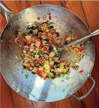  ?? (Gretchen McKay/Pittsburgh Post-Gazette/ TNS) ?? Leftover rice paired with cooked salmon and chopped veggies means a healthful dinner in a flash.