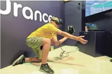  ?? ASSOCIATED PRESS ASSOCIATED PRESS ?? Dennis Milman reaches to catch a virtual ball at the All-Star FanFest in Miami Beach, Fla. Virtual reality baseball is a hit at the All-Star FanFest. Fans get to feel what it's like to be the San Francisco Giants' Buster Posey catching without the pain...