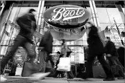  ?? SERGIO DIONISIO/ AP ?? People walk past a Boots pharmacy on Oxford Street in central London yesterday. Alliance UniChem PLC and Boots PLC plan to join forces to become Alliance Boots.