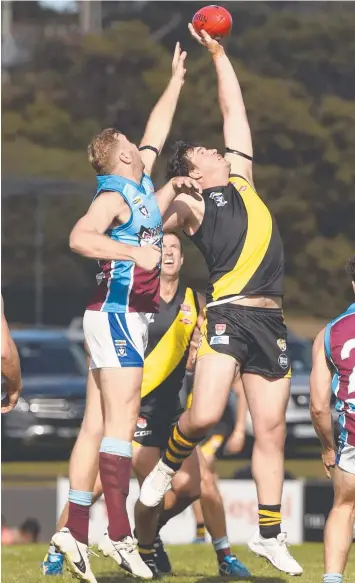  ?? Pictures: ALAN BARBER ?? TIGER TAP: John Meesen (Modewarre) and Jake Reeves (Torquay) contest a ball-up (above). Josh Finch addresses his teammates at quarter-time (left).