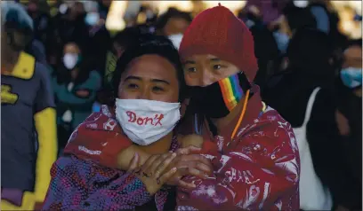  ?? PHOTOS BY JANE TYSKA — STAFF PHOTOGRAPH­ER ?? Two women embrace during an anti-Asian hate vigil at Chinatown’s Madison Park in downtown Oakland on Tuesday. It marked one week since the slaying of eight people at Atlanta spas, six of whom were women of Asian descent.