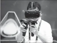  ?? AFP ?? A man uses a HTC virtual reality mask to play a game at the Global Mobile Internet Conference in Beijing.