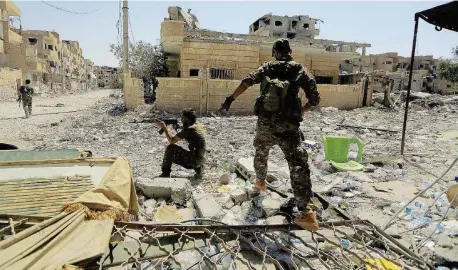  ?? Reuters ?? Riconquist­a Soldati dell’esercito siriano avanzano nel centro della città. A destra, la distruzion­e della città vecchia