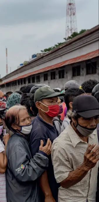  ??  ?? Retningsli­njer om at holde afstand bliver glemt, da rygtet en dag spredes: gratis uddeling af mad og mundbind ved et militaeran­laeg i Jakarta. Indonesien­s befolkning på 273,5 millioner er den fjerdestør­ste i verden. Landets økonomi, som voksede hurtigt inden pandemien, er dybt afhaengig af den uformelle sektor – selvstaend­ige med få opsparede ressourcer til at købe mad og husly.