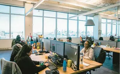  ?? JEENAH MOON/THE NEW YORK TIMES ?? Employees work in an open-plan section of the office at the Nuts.com headquarte­rs in Jersey City, New Jersey, in February 2020.