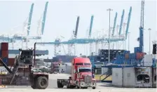  ?? AP FILE PHOTO/WILFREDO LEE ?? A truck leaves the docks at PortMiami in Miami. The U.S. economy shrank at an alarming annual rate of 31.7% during the April-June quarter as it struggled under the weight of the viral pandemic, the government estimated Thursday.