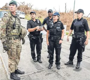  ?? Picture: PA. ?? Major Tom Quinn of 40 Commando and UK Police lead Supt Sharon Bush, second right, as British Royal Marines and police assist in an operation to secure the inmates of Balsam Ghut prison, in Tortola.