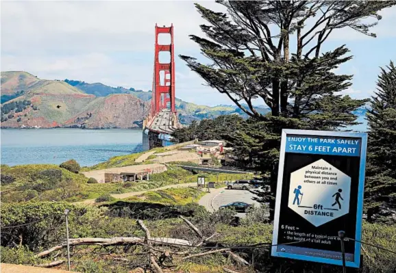  ?? JIM WILSON/THE NEW YORK TIMES ?? A sign along a trail near the Golden Gate Bridge on April 12 urges people to observe social distancing and stay at least 6 feet apart amid the coronaviru­s pandemic in San Francisco.