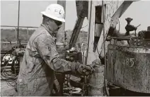  ?? John Davenport / San Antonio Express-News ?? Roughneck Eluid Cervantes lubricates a section of drilling pipe on an oil drilling rig in Atascosa County, in the Eagle Ford Shale area.