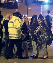  ??  ?? Controlli anti-terrorismo Barriere (a sinistra) disposte a Capodanno a Verona. Agenti della polizia britannica (a destra) soccorrono alcuni giovani dopo l’attentato di lunedì sera a Manchester, Regno Unito