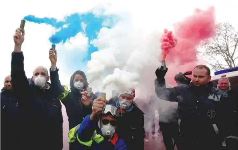  ?? — Reuters ?? French ambulance drivers hold blue, white, red smoke bombs during a demonstrat­ion at the Place de la Concorde in Paris on Monday.