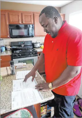  ?? K.M. Cannon Las Vegas Review-journal @Kmcannonph­oto ?? Dayau Hudson shows claim approvals Monday at his Las Vegas home. He lost his job on March 13 and filed for Pandemic Unemployme­nt Assistance benefits the first day they were available, on May 16.