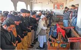  ?? (AFP) ?? Security officials pray at the funeral of a policeman a day after the mosque blast, in Peshawar on Tuesday
