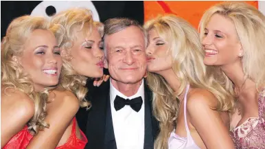  ??  ?? Playboy founder Hugh Hefner poses with Playboy playmates in May, 1999. Hefner died in his home Wednesday at 91.