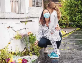  ?? ALYSSA POINTER/ATLANTA JOURNAL-CONSTITUTI­ON ?? Mallory Rahman and her daughter Zara place flowers near a makeshift memorial outisde the Gold Spa in Atlanta on Wednesday. Police say they have begun extra patrols in and around Asian businesses there after eight people died in three shootings.