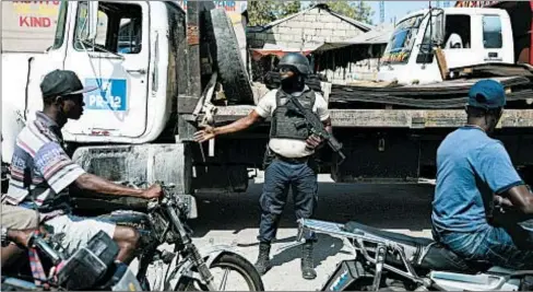  ?? AP ?? A police officer directs traffic Wednesday in Port-au-Prince, Haiti. Gangs are said to control much of the country’s capital city.