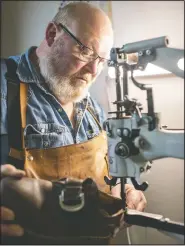  ?? (Sioux City Journal/Jesse Brothers) ?? Mark Heft, a cobbler, uses a leather patcher industrial sewing machine to repair a shoe at his store in Transit Plaza, in Sioux City, Iowa.