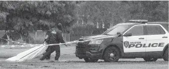  ?? Yi-Chin Lee / Staff photograph­er ?? HPD authoritie­s remove a man’s body Friday at Beverly Hills Park. The victim was shot multiple times in the torso and head, police said.