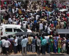  ??  ?? Pedestrian­s gather near the house where Indian police found 11 bodies in Burari village, north Delhi, India. Photo: AP